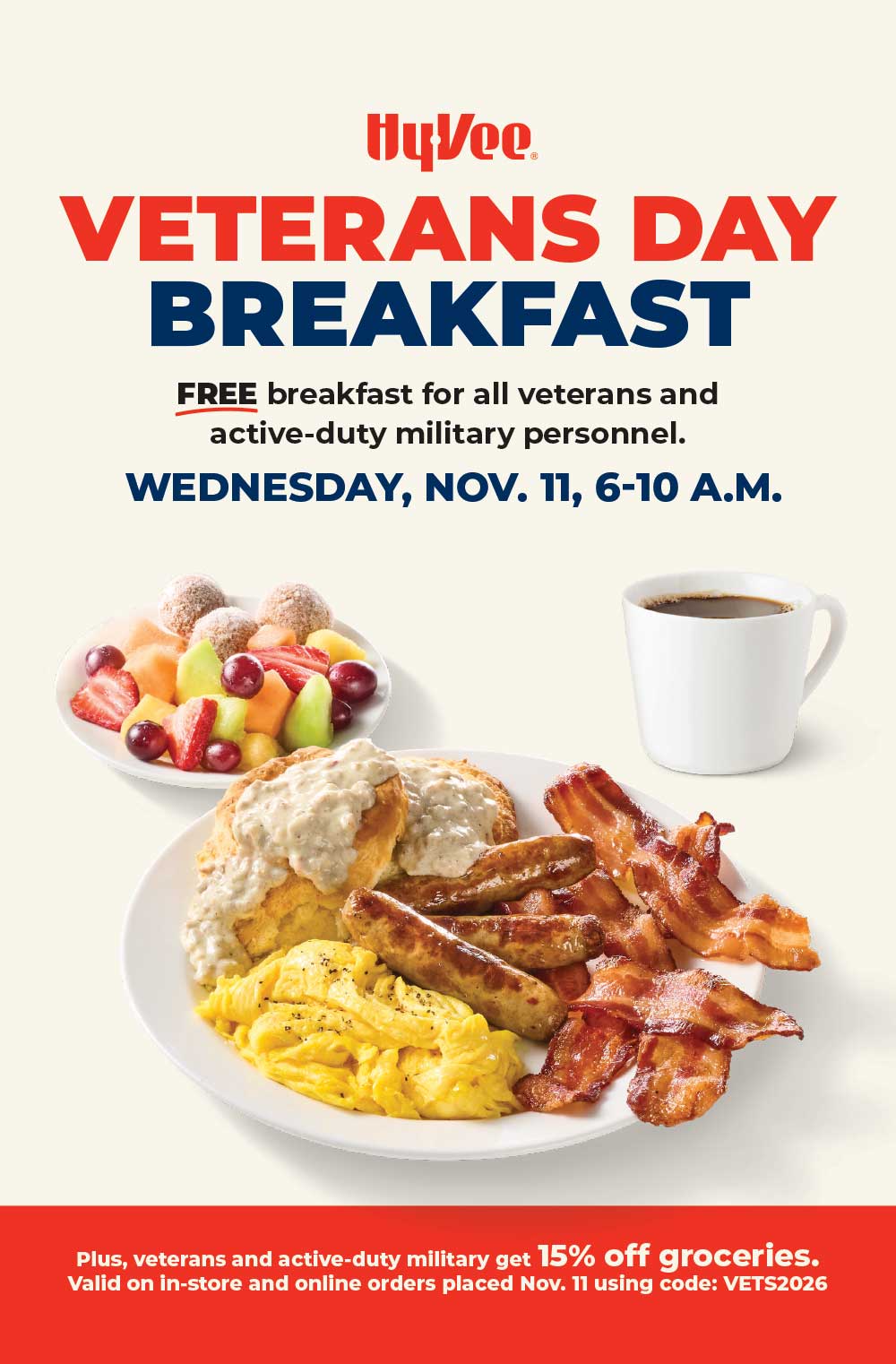 Hy-Vee Veterans Day Breakfast: a plate of biscuits and gravy, scrambled eggs, sausage links and bacon, with a side of fruit and doughnut holes and a cup of coffee.